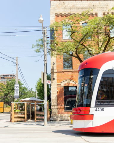 Toronto streetcar passing a brick building and patio on King West
