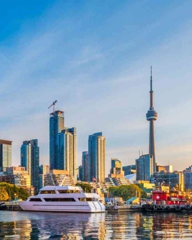 Toronto skyline at sunset viewed from the harbour, with the CN Tower and waterfront